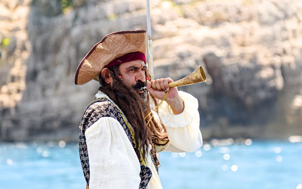Pirate blowing horn on Vlora Ionian Odyssey boat tour, Albania.
