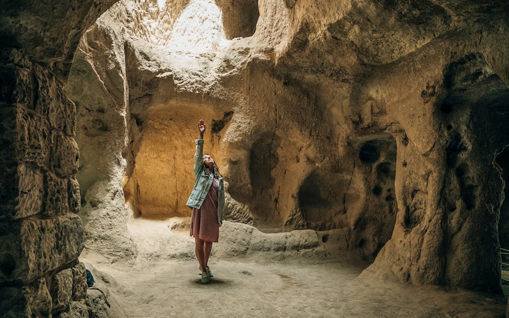 Young tourist woman exploring Derinkuyu underground cave city.