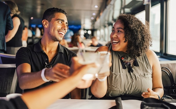 Couple toasting drinks on a Chicago dinner cruise.