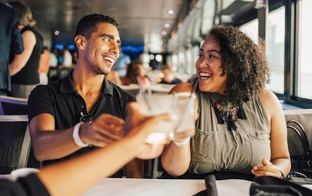 Couple toasting drinks on a Chicago dinner cruise.
