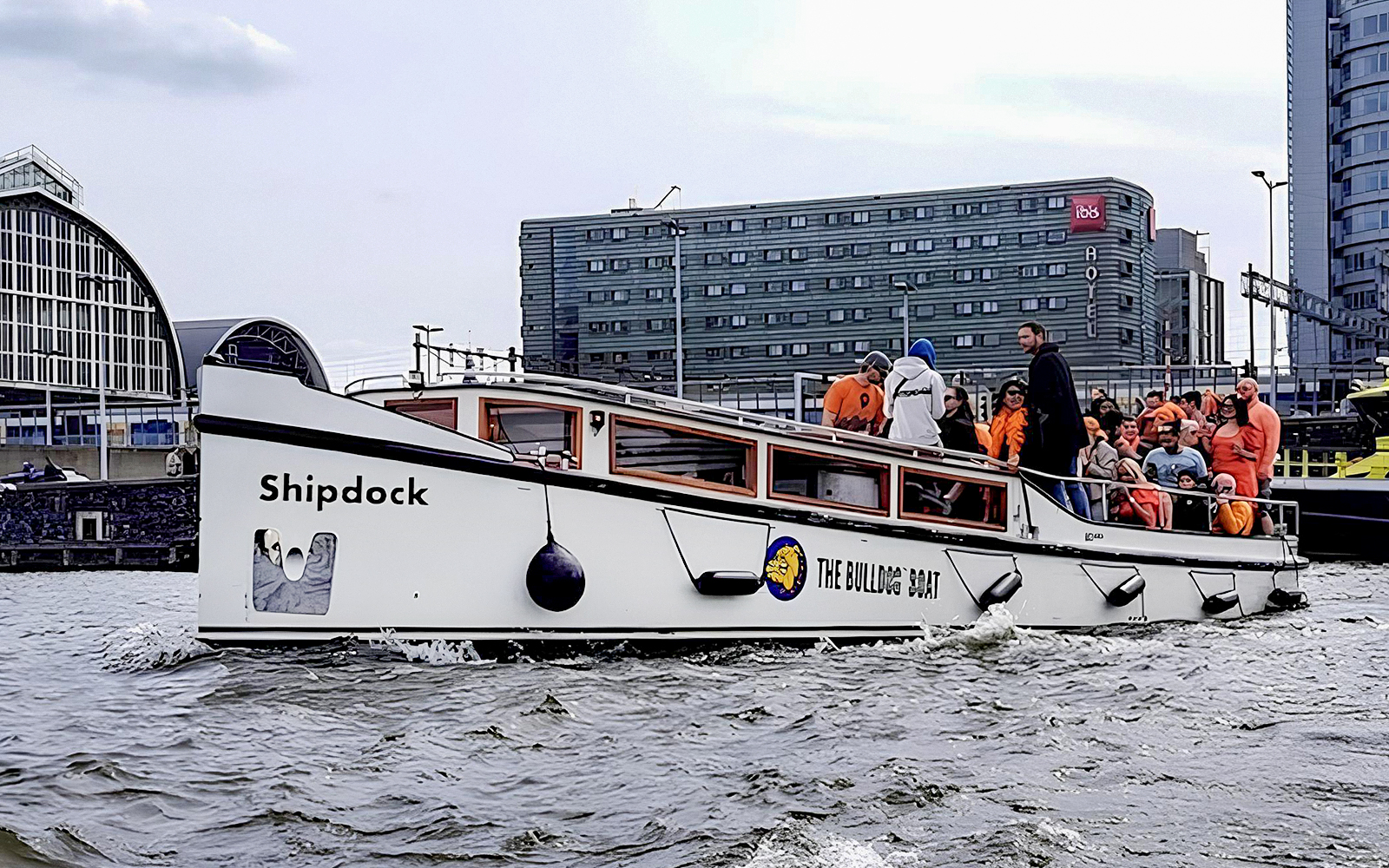 Amsterdam canal cruise boat with passengers enjoying a smoke-friendly tour.