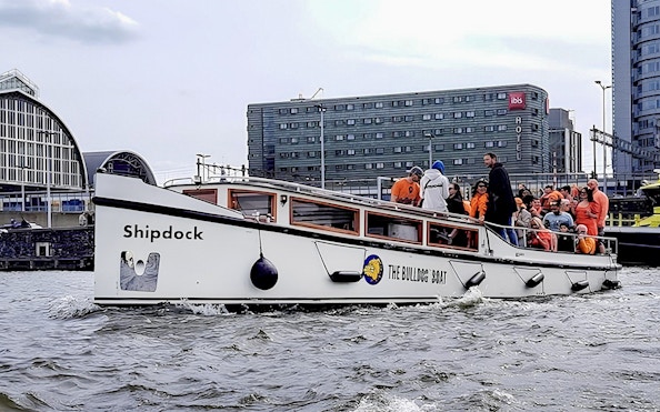 Amsterdam canal cruise boat with passengers enjoying a smoke-friendly tour.
