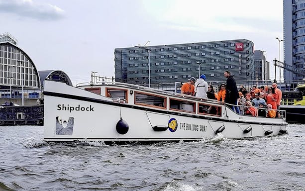 Amsterdam canal cruise boat with passengers enjoying a smoke-friendly tour.