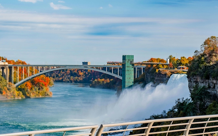 Niagara Falls view with bridge and observation tower during boat tour.