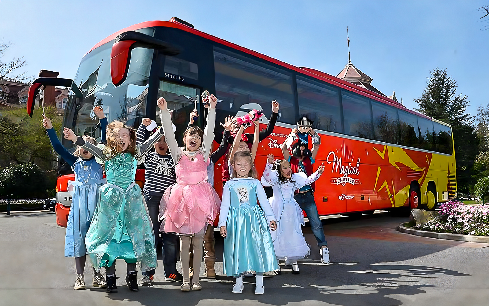 Young girls in costumes celebrating near the Magical Shuttle at Disneyland Paris.