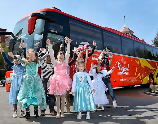 Young girls in costumes celebrating near the Magical Shuttle at Disneyland Paris.
