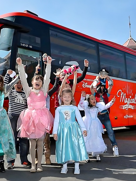 Young girls in costumes celebrating near the Magical Shuttle at Disneyland Paris.