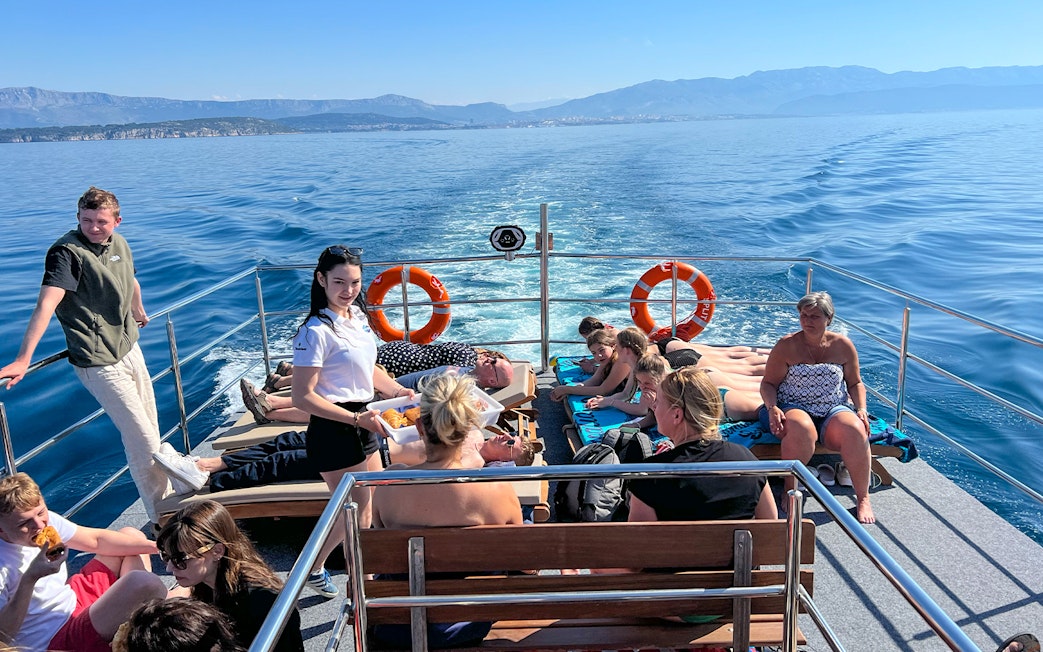 Group enjoying a boat cruise on the Blue Lagoon Šolta with scenic views of the Adriatic Sea.