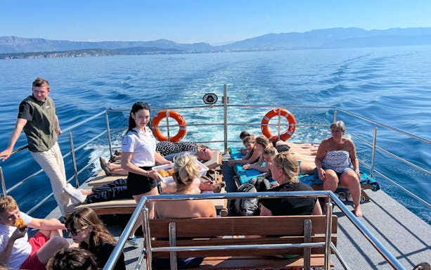 Group enjoying a boat cruise on the Blue Lagoon Šolta with scenic views of the Adriatic Sea.