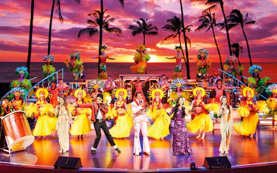 Performers in traditional Hawaiian attire on stage at RockAHula Show, Honolulu.
