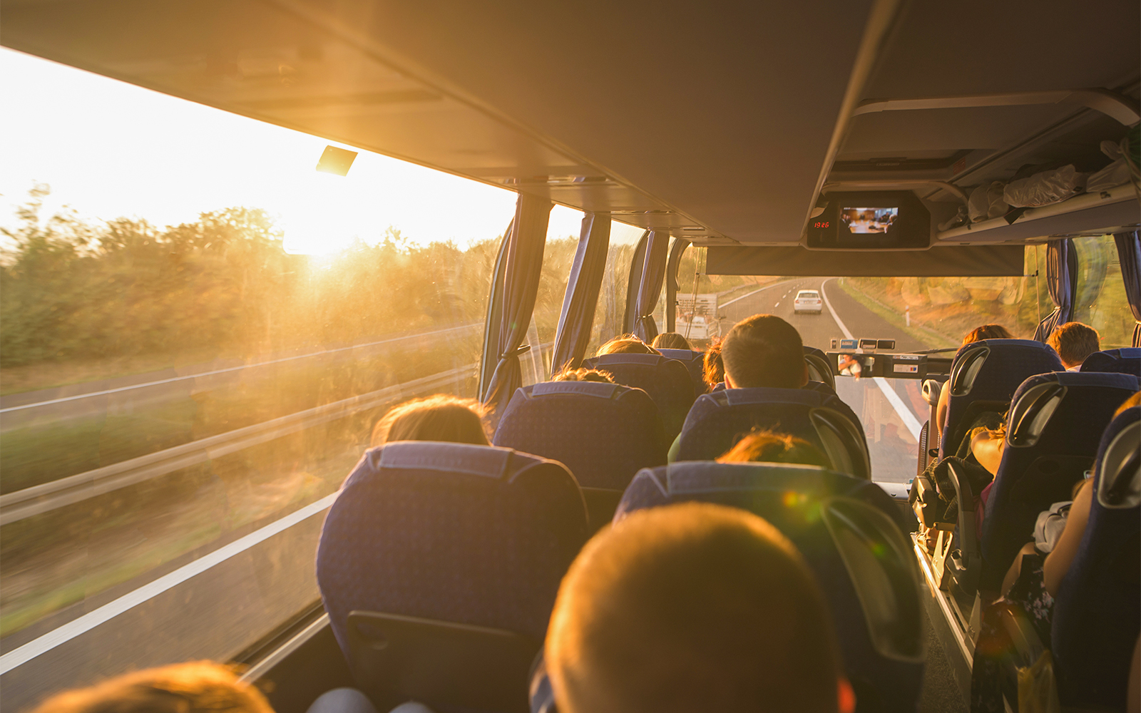 Passengers on a bus traveling to tandem skydiving in Cairns at sunset.