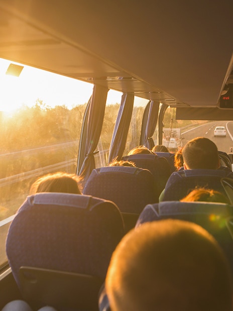 Passengers on a bus traveling to tandem skydiving in Cairns at sunset.