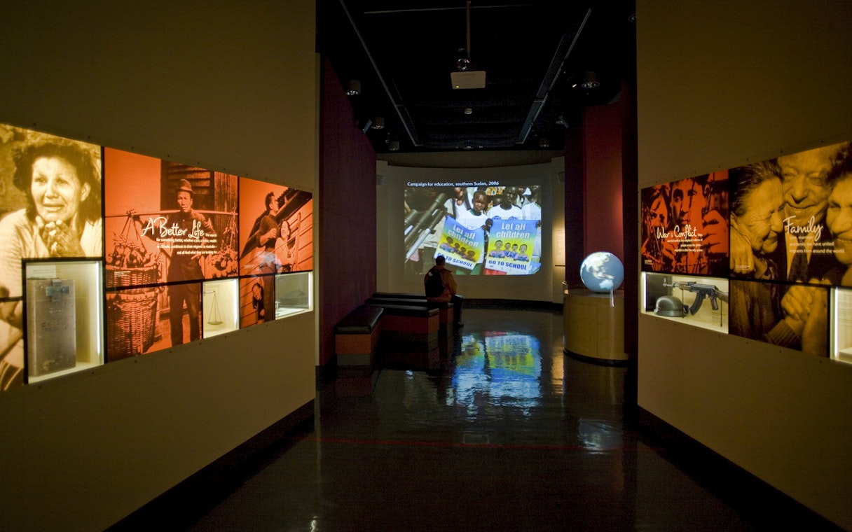 War and Family Migration displays at Immigration Museum tour, featuring global education campaign.