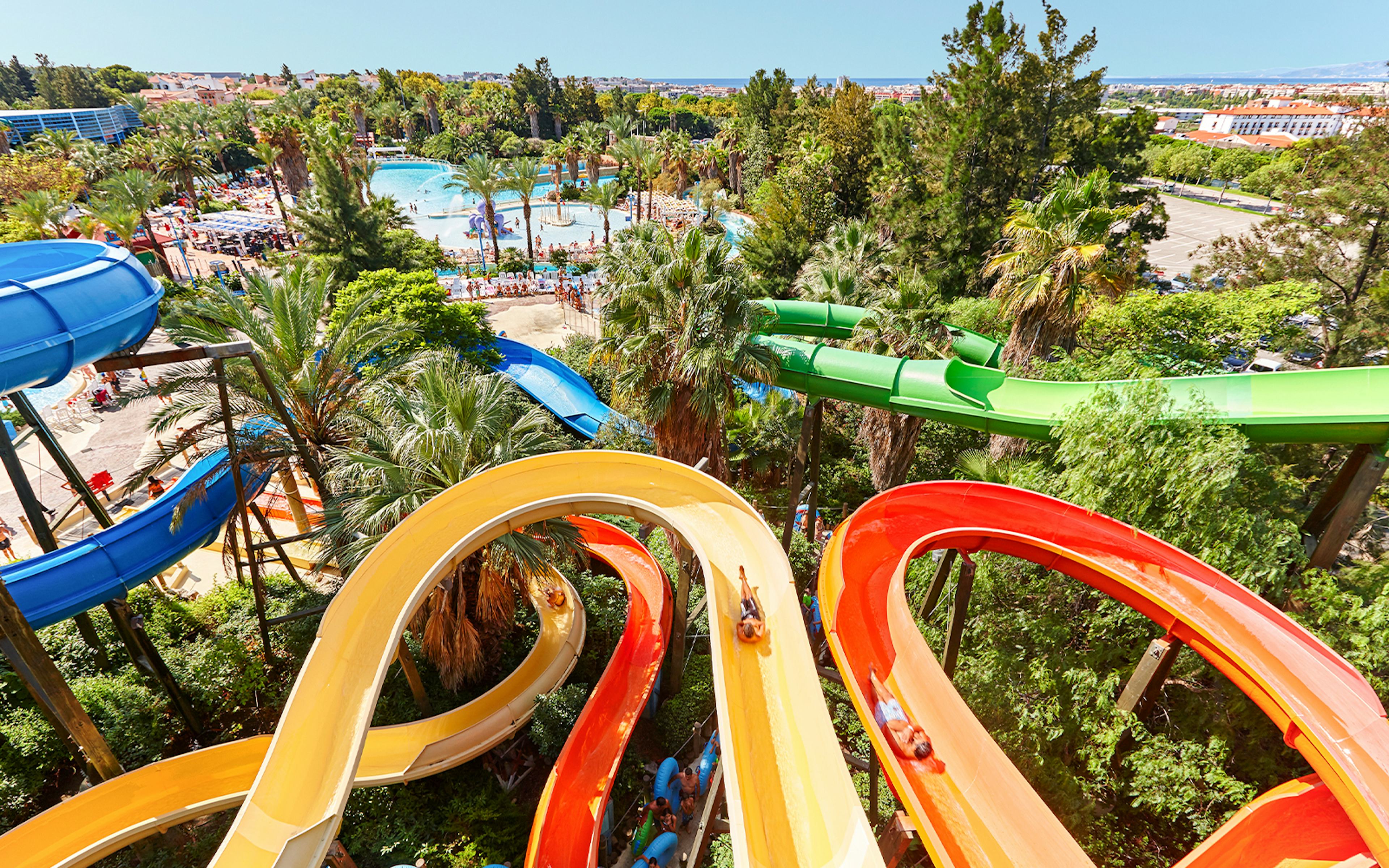 Water slides and pools with palm trees at Costa Caribe Aquatic Park, Barcelona.
