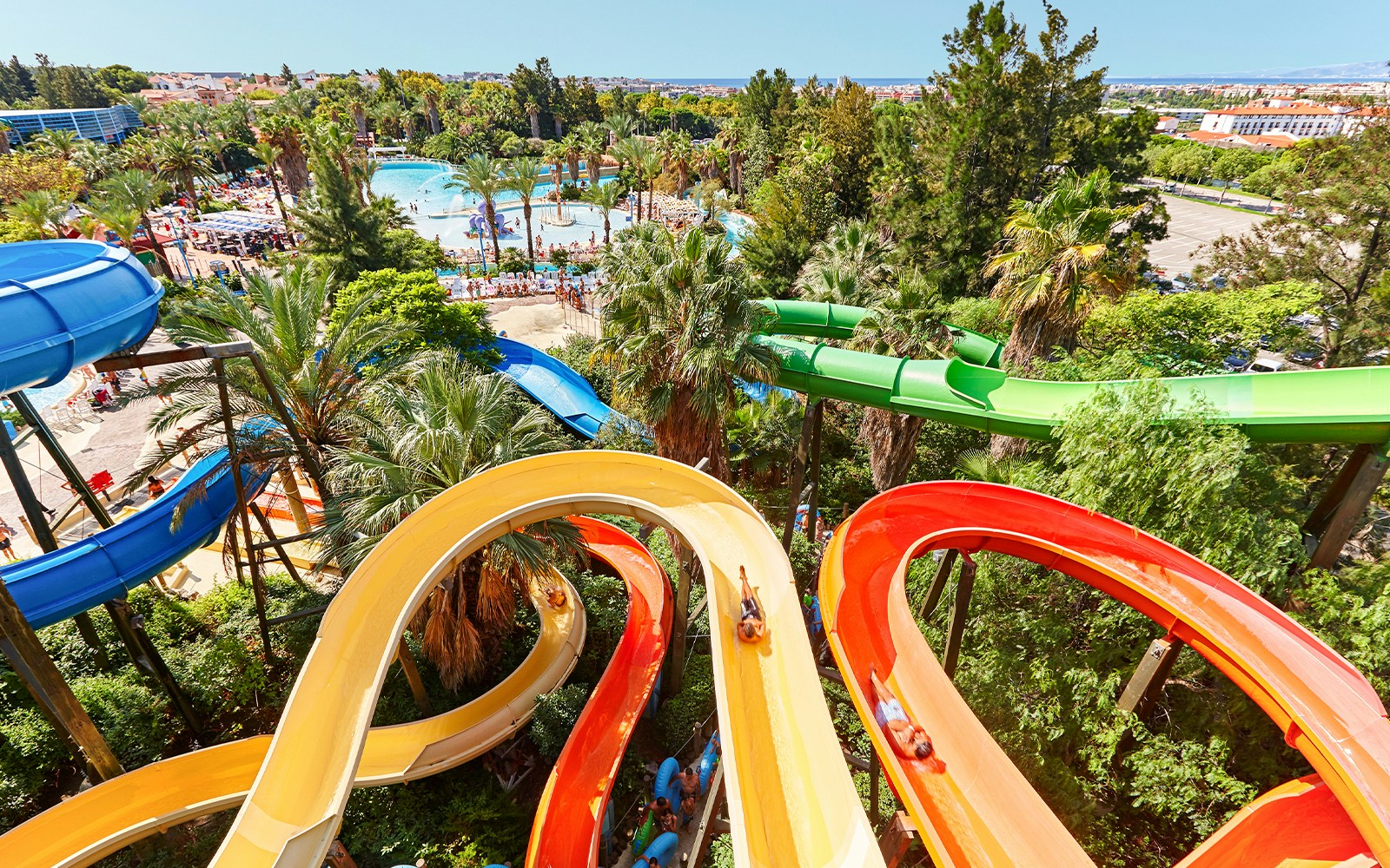 Water slides and pools with palm trees at Costa Caribe Aquatic Park, Barcelona.