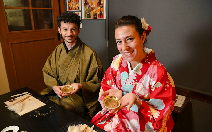 Couple in kimonos at a gold leaf workshop in Japan.