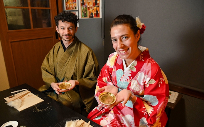Couple in kimonos at a gold leaf workshop in Japan.