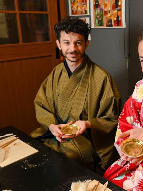 Couple in kimonos at a gold leaf workshop in Japan.