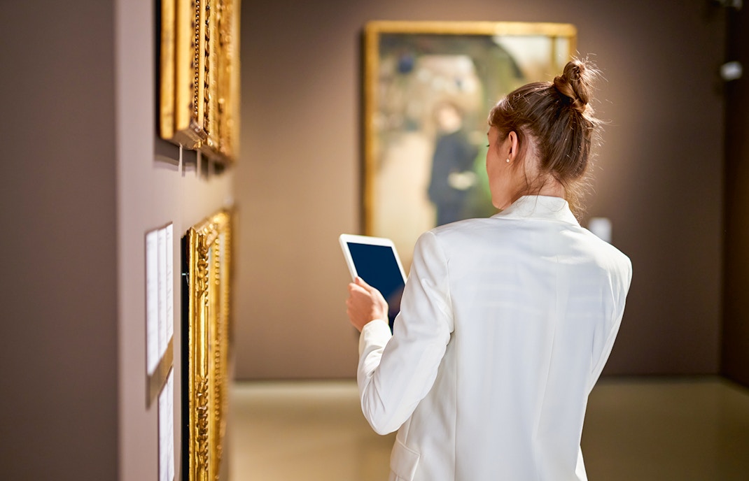 Louvre museum visitors viewing famous art pieces in Paris, France.