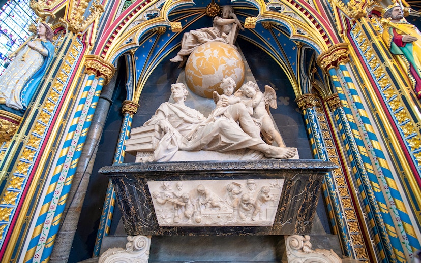 Marble monument inside Westminster Abbey with colorful arches and detailed sculptures.