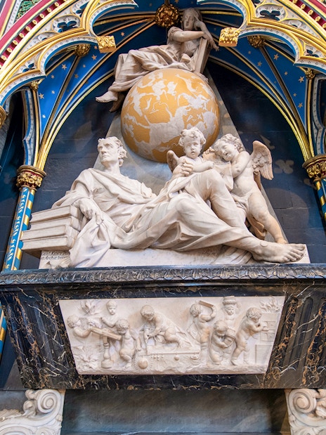 Marble monument inside Westminster Abbey with colorful arches and detailed sculptures.
