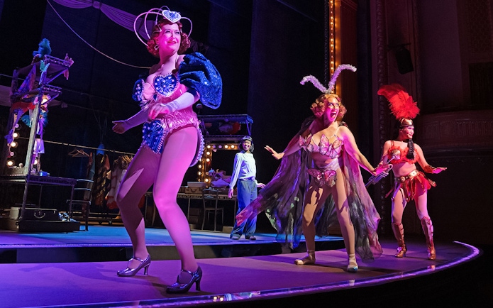 Performers in vibrant costumes on stage during a theatrical production of Gypsy.