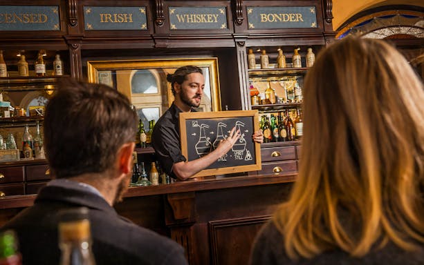 Guests learning about whiskey distillation at the Irish Whiskey Museum tour.