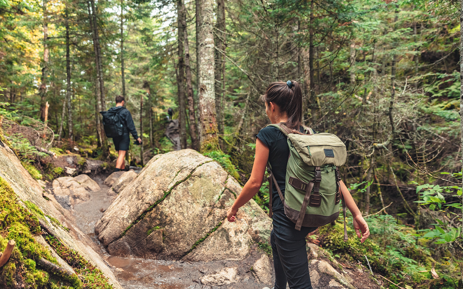 Couple hiking through forest trail towards Piscina Irgas waterfall.