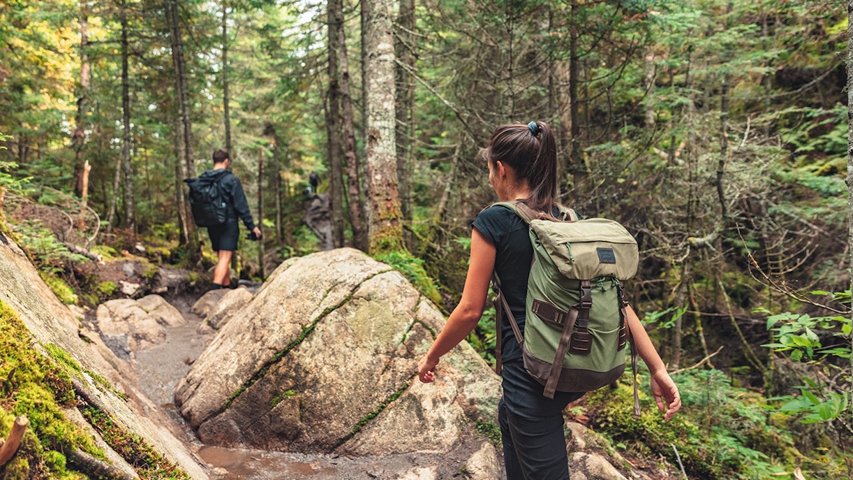Couple hiking through forest trail towards Piscina Irgas waterfall.