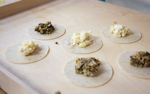 Dumpling wrappers with various fillings at a Polish cooking class.