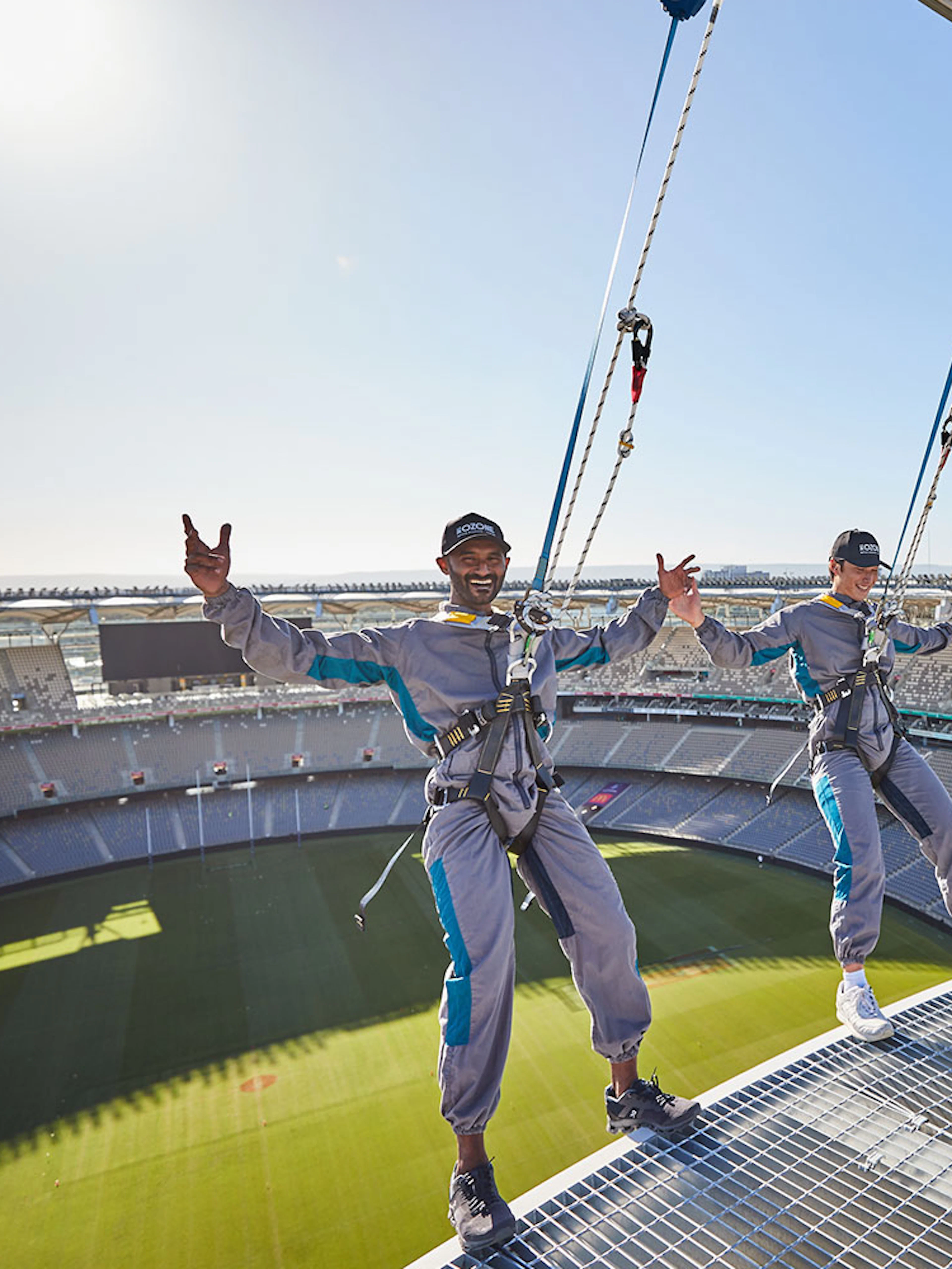 Visitors harnessed on Optus Stadium roof during Vertigo experience in Perth, Australia.