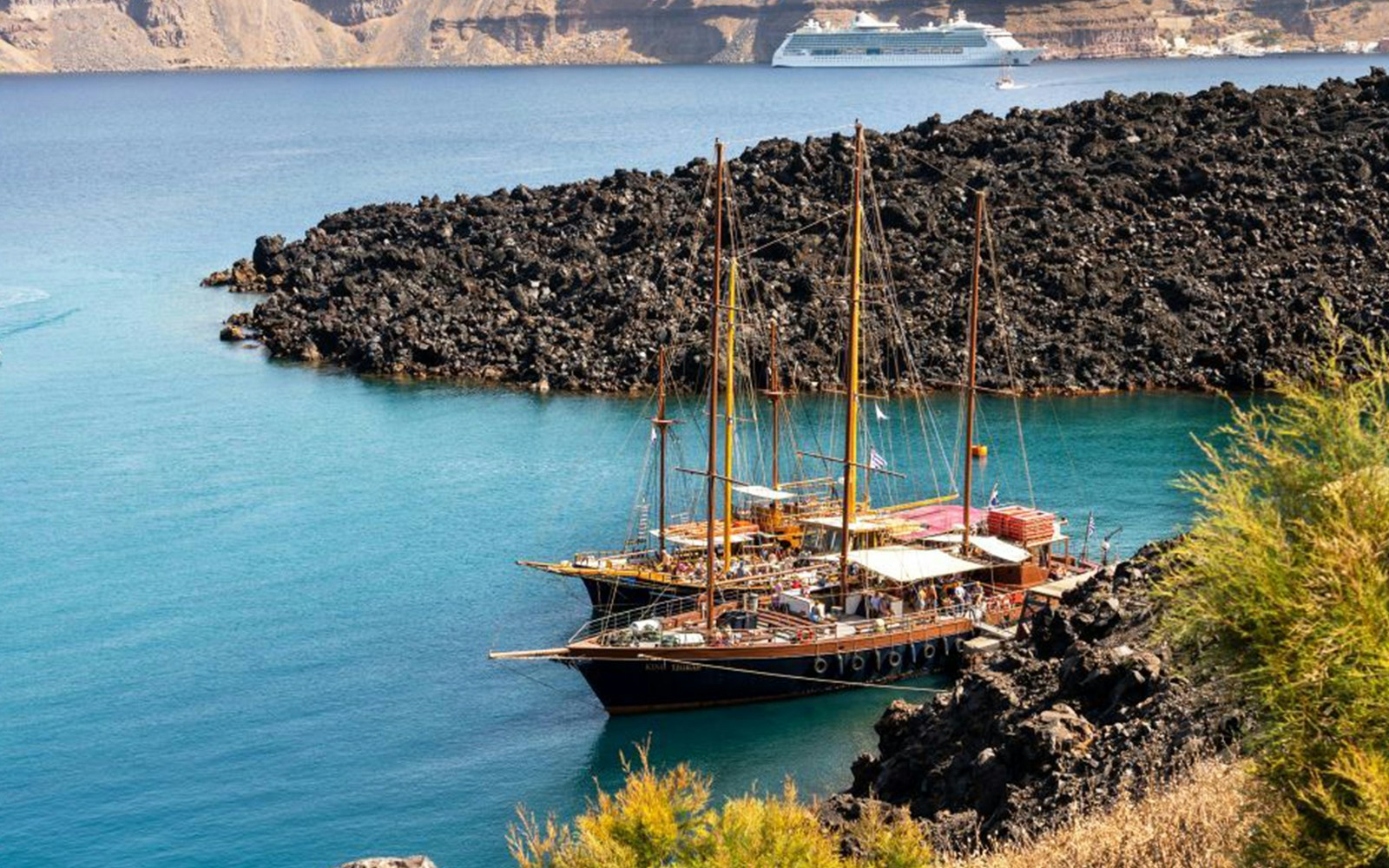 Santorini volcanic islands boat tour with view of caldera, hot springs, and Thirassia in Greece.