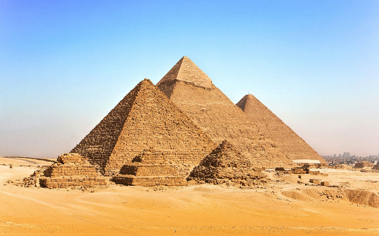 Pyramids of Giza on the Giza Plateau under a clear blue sky.