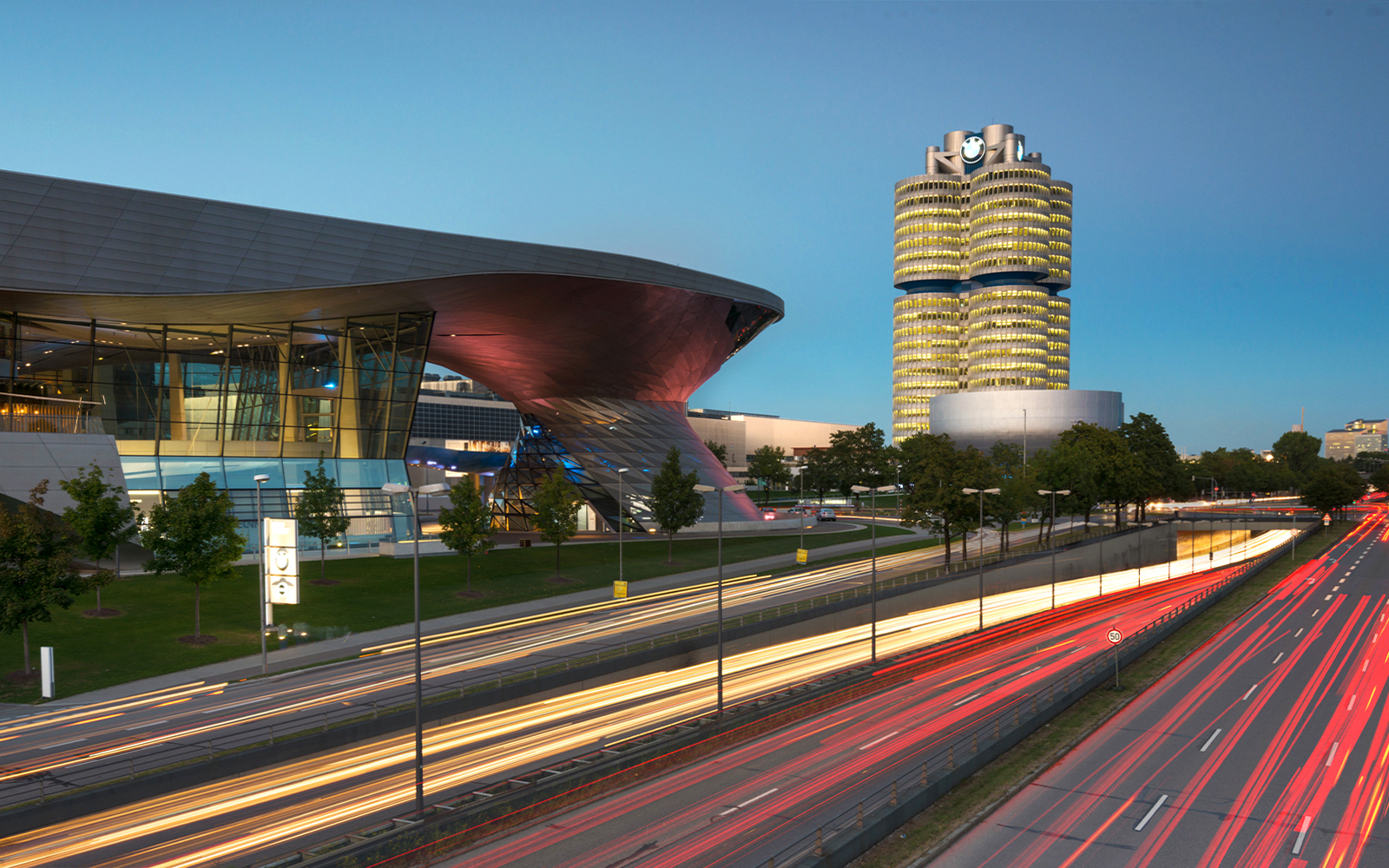 BMW Welt and Headquarters in Munich at dusk with light trails from passing cars.