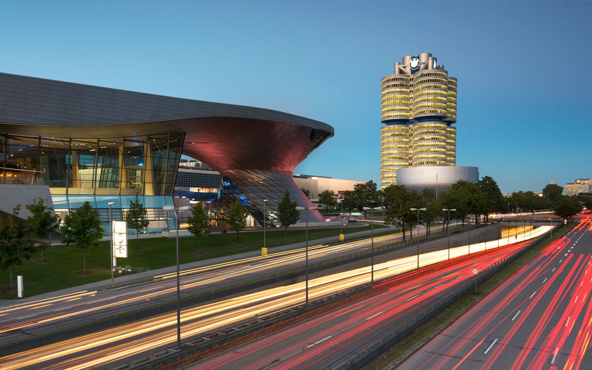 BMW Welt and Headquarters in Munich at dusk with light trails from passing cars.