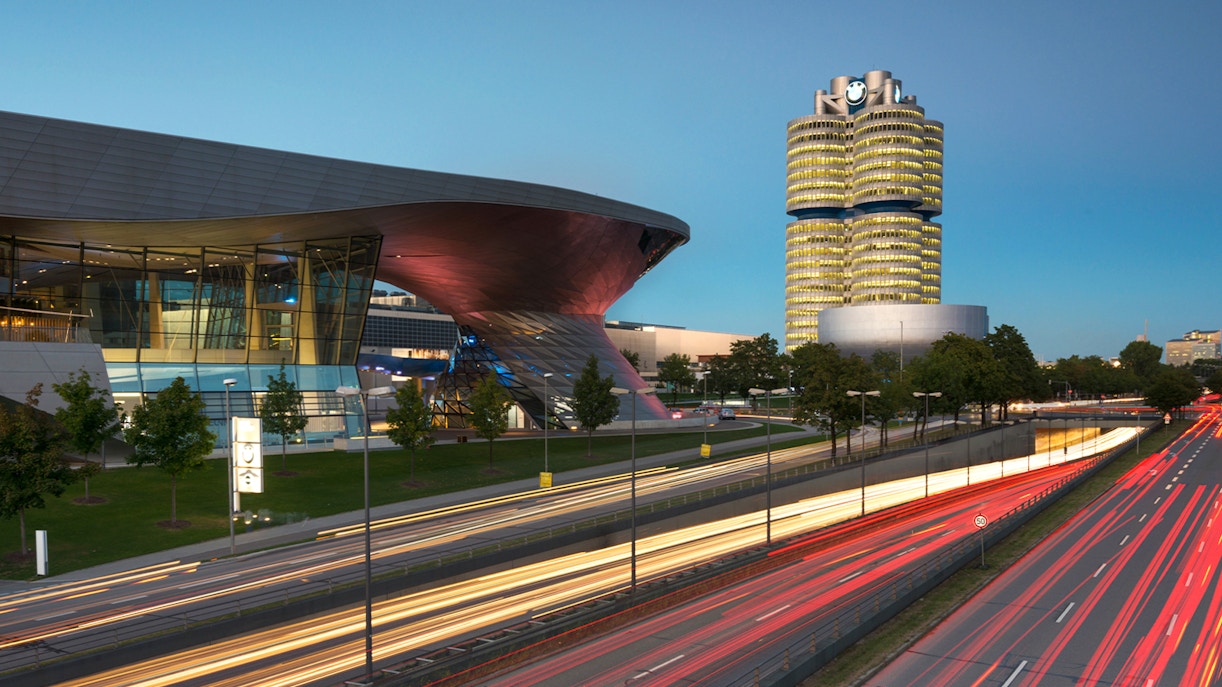 BMW Welt and Headquarters in Munich at dusk with light trails from passing cars.