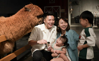 Family interacting with an alpaca at Just Farm Indoor Zoo Kuala Lumpur.