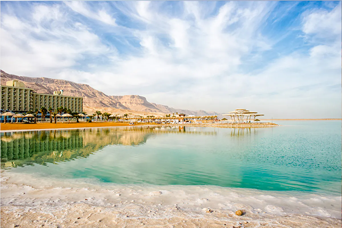 Dead Sea shoreline with resort and mountains, Amman half-day trip.