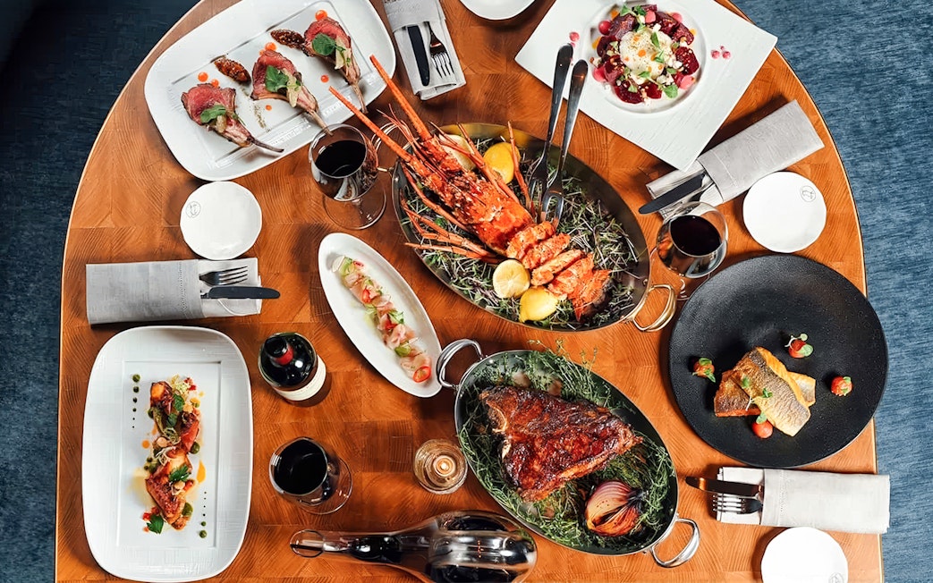 Dinner spread at Baha Mar Resort in Nassau, Bahamas featuring lobster, steak, and gourmet dishes.