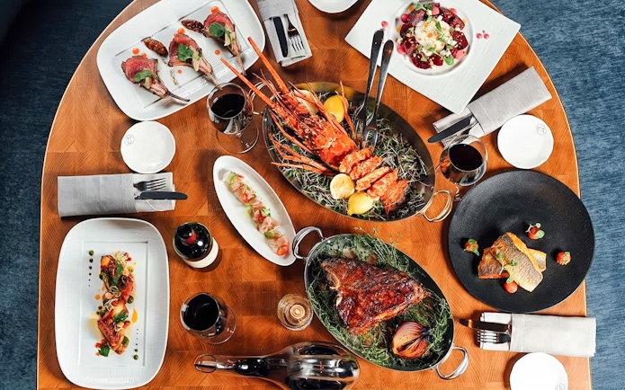 Dinner spread at Baha Mar Resort in Nassau, Bahamas featuring lobster, steak, and gourmet dishes.