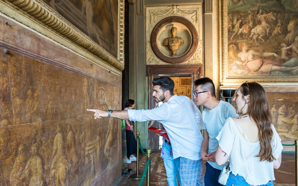 Guided group exploring frescoes in Palazzo Vecchio Museum, Florence.