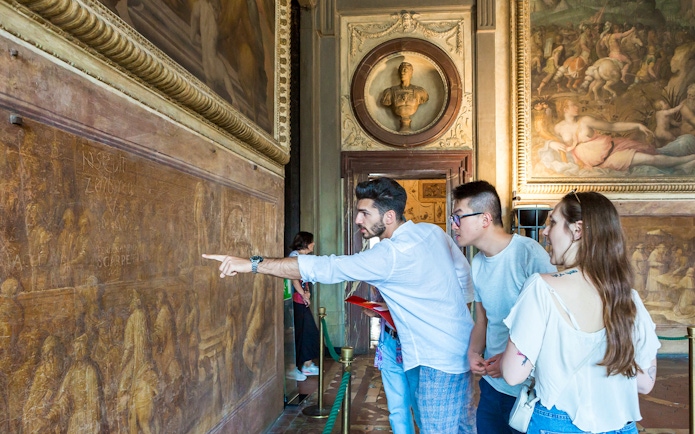 Guided group exploring frescoes in Palazzo Vecchio Museum, Florence.