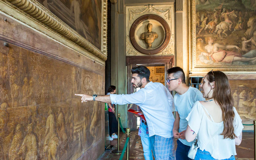 Guided group exploring frescoes in Palazzo Vecchio Museum, Florence.