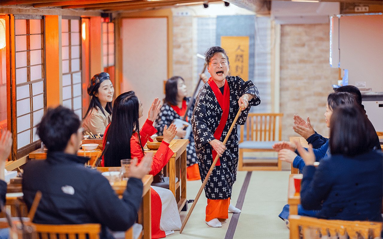Cultural performance on Yakatabune Cruise with performer engaging guests in traditional attire.