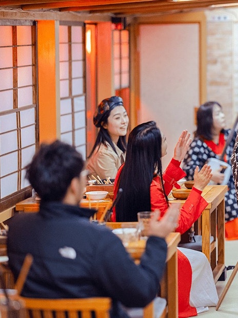 Cultural performance on Yakatabune Cruise with performer engaging guests in traditional attire.