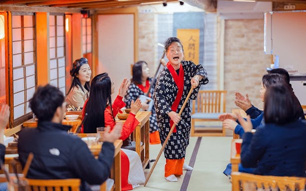 Cultural performance on Yakatabune Cruise with performer engaging guests in traditional attire.