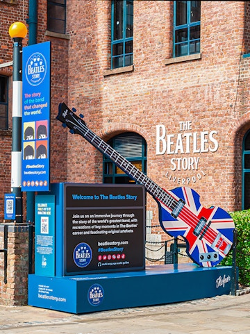Exteriors of The Beatles Story museum in Liverpool with Union Jack guitar display.