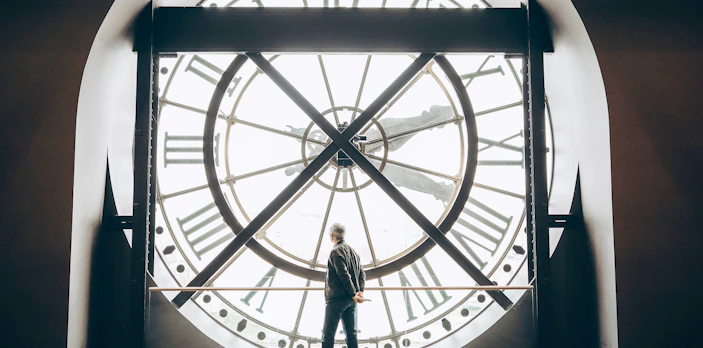 Tourist viewing through the large clock face inside Orsay Museum, Paris.