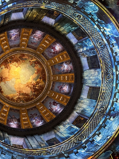 Dome interior with vibrant frescoes at Invalides Aura Immersive Experience, Paris.