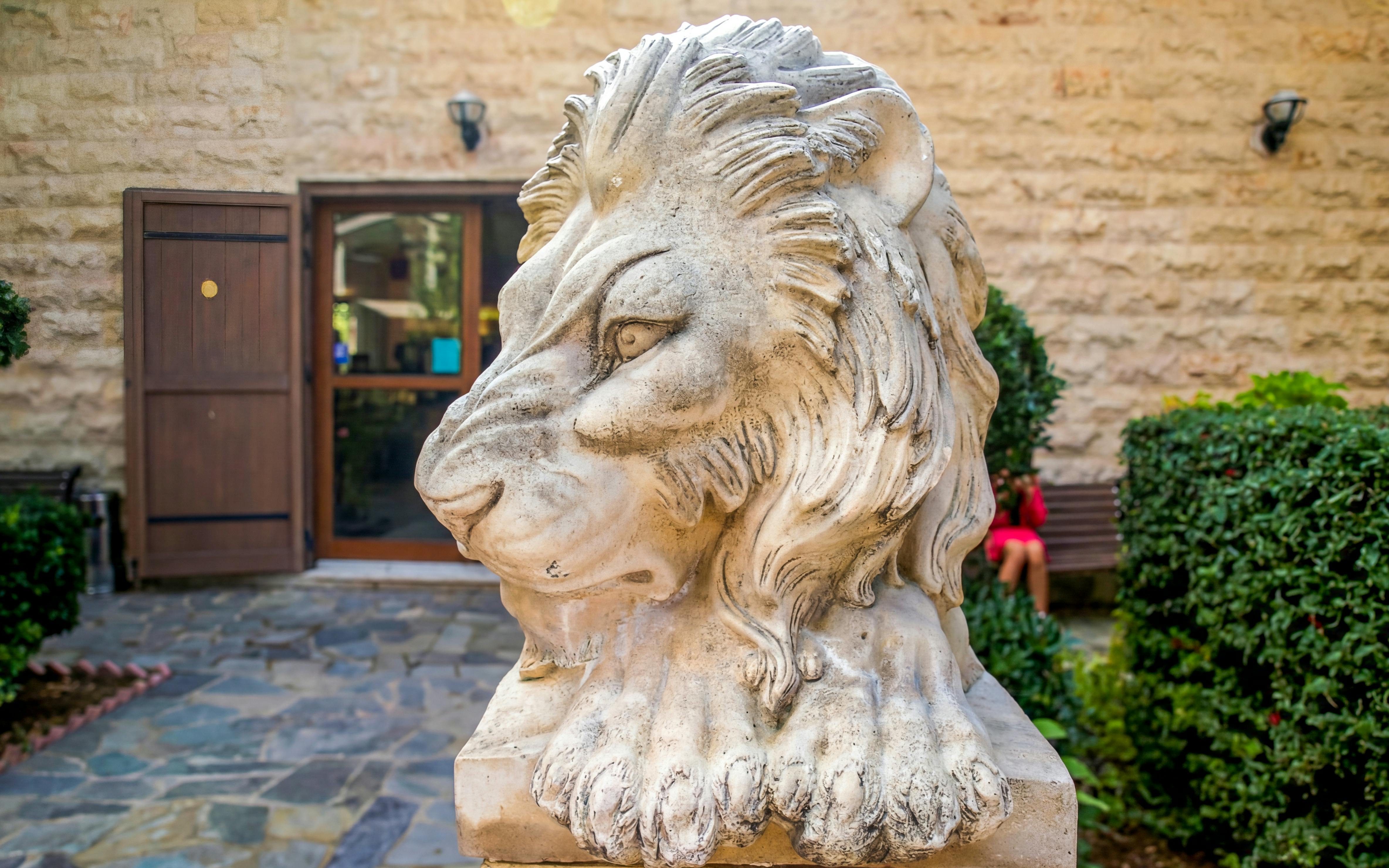 Stone lion statue at a winery entrance in Troodos Mountains, Cyprus.